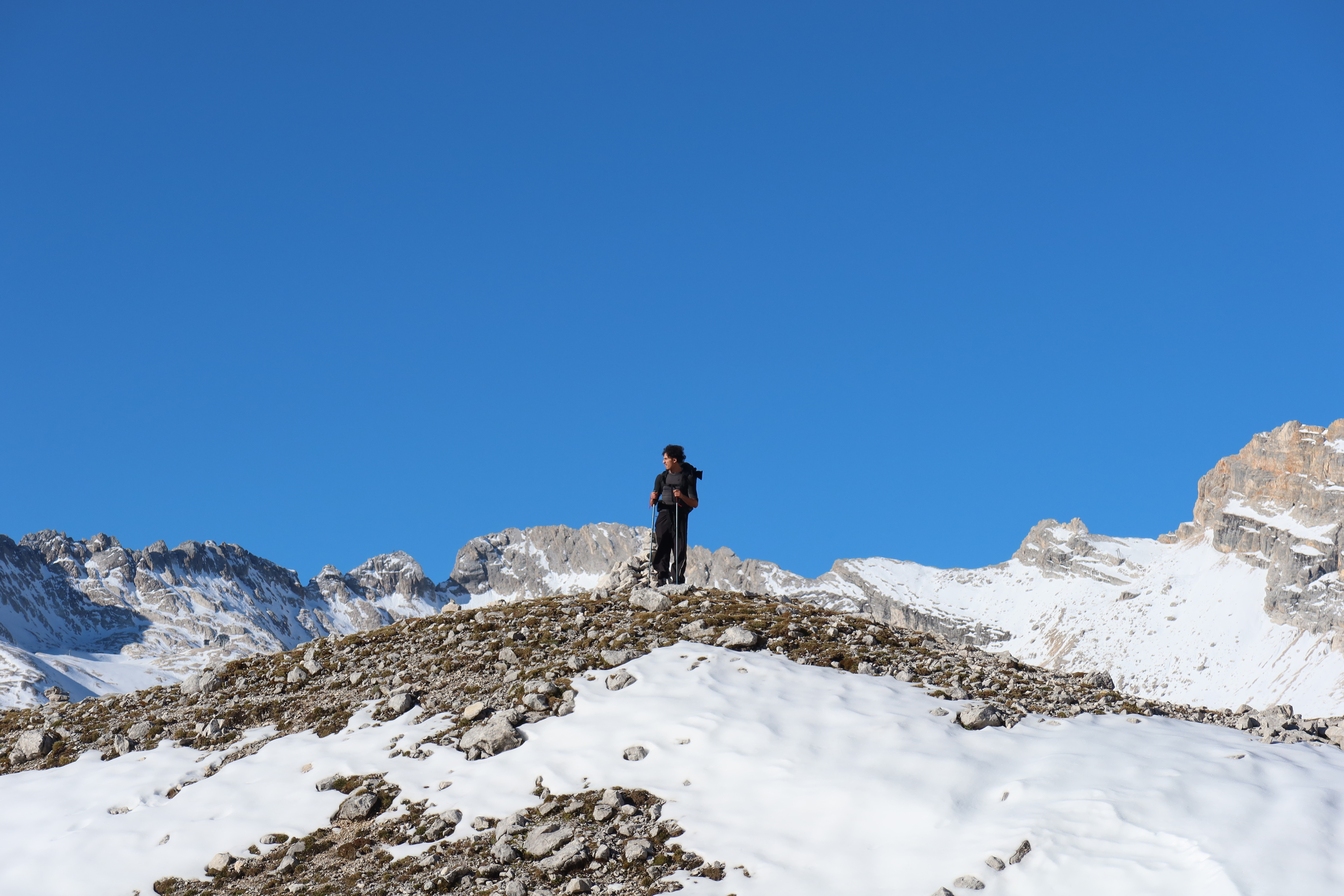 Wandelaar tussen besneeuwde bergtoppen